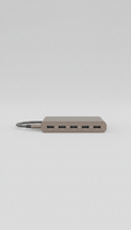 Minimalist USB-C hub, Default angle is a clean three-quarter view at tabletop height — showcases product form and...