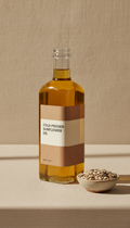 SatNutro Cold-Pressed Sunflower Oil, Single bottle placed three-quarter to camera at slight angle for depth; softly lit...